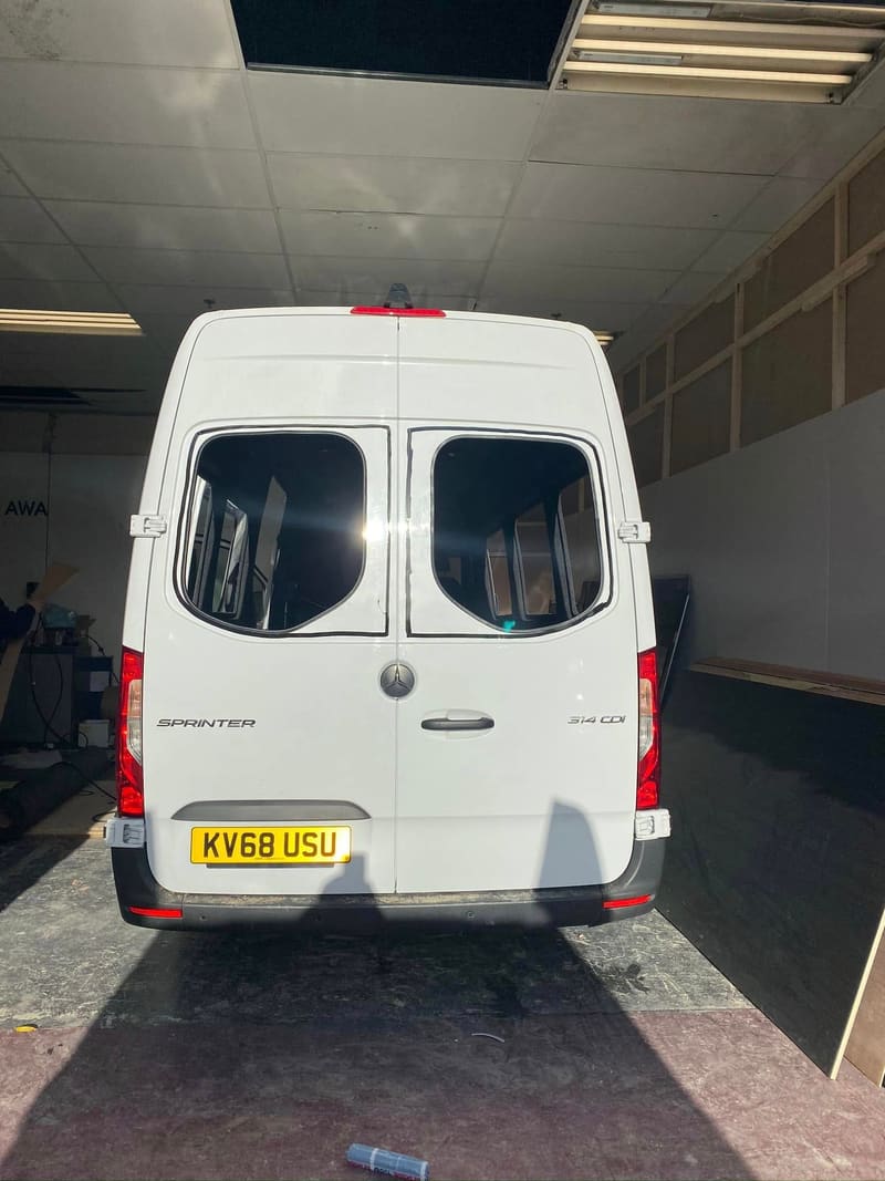The rear doors of a white Mercedes Sprinter with matching glass bonded into both door panels